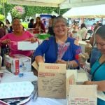 Beneficiarias desempaquetando y examinando con entusiasmo sus nuevos kits de repostería.