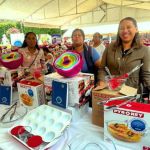 Beneficiarias felices mostrando una variedad de utensilios y kits de repostería nuevos.