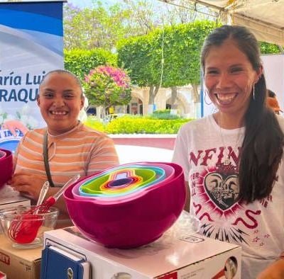 Dos beneficiarias felices mostrando sus kits de repostería con tazones multicolores.