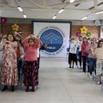 Participantes moviendo sus brazos al ritmo de la dinámica con entusiasmo