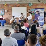 Participantes disfrutando de show de cantantes y guitarristas