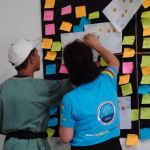 Beneficiario coloca notas adhesivas en un tablero
