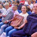 Beneficiarios muestran los morrales donados por la fundación