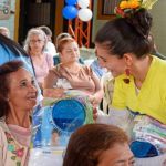Mujer adulta mayor mira con felicidad a una voluntaria al recibir su kit de aseo
