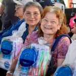 Sonrientes dos mujeres adultas mayores muestran su alegría con su kit de aseo