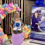 Mujer adulta mayor muestra su kit de aseo con gestos de felicidad