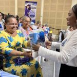Una participante recibe con alegría su kit de aseo