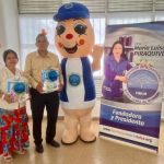 Hormy alegre posa junto con beneficiarios después de recibir kits de aseo