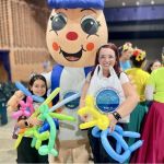 Nuestra simpática mascota institucional, Hormy, posa con una gran sonrisa junto con dos participantes en la jornada