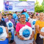 Familias felices con el mercado recibido. Todos sonríen mientras sostienen la ayuda en sus manos.