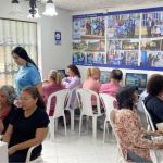 Voluntaria asistiendo a los estudiantes durante una clase práctica del curso de sistemas