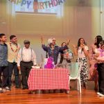 Con energía festiva, participantes están sonriendo, cantando y expresándose con libertad.