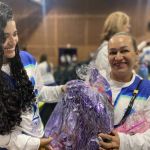 Una voluntaria recibe en sus manos un obsequio con una sonrisa en su rostro
