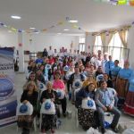 Los beneficiarios posan con los mercados entregados por la Fundación junto con los voluntarios que participaron durante la jornada