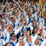 Con manos arriba los voluntarios cantan el himno de la Fundación