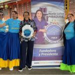 Beneficiaria disfruta una foto institucional con nuestras coloridas voluntarias después de la entrega de mercados