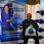 Beneficiario disfruta de foto institucional con el pendón de la Dra. María Luisa