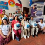 Fotografía institucional general con el péndon de la Dra. María Luisa con beneficiarios y voluntarios