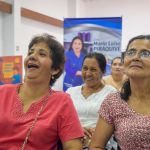 Beneficiarios felices Participantes reciben orientación y beneficios en un ambiente amable y organizado.