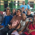 Beneficiarios felices Participantes reciben orientación y beneficios en un ambiente amable y organizado.