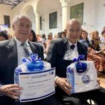 Con felicidad dos hombres recibieron obsequios y sostienen diploma de graduados del programa Bienestar para la Persona Mayor