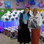 Beneficiaria recibe un regalo por su participación en la jornada y expresa su entusiasmo con una sonrisa