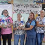 En un momento de satisfacción, beneficiarias posan con orgullo exhibiendo los regalos que ganaron durante las dinámicas de la jornada