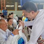 Con sorpresa y gratitud un beneficiario recibe su beneficio de parte de un voluntario