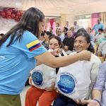 Beneficiaria recibe con una mirada llena de gratitud y sonrisa esperanzadora el beneficio de mercado