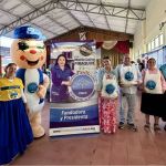Foto institucional con el pendón de la Dra. María Luisa y Hormy, mascota de la Fundación