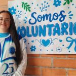 Voluntaria posando en cartelera decorativa de "Somos voluntarios"