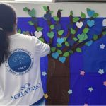 Voluntaria comparte su participación en una actividad de mural de arbol