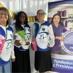 Voluntarios posando con regalos durante el evento