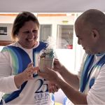 En un momento de gratitud cercanía voluntarios extienden con felicidad sus manos para recibir los obsequios entregados durante la jornada.
