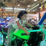 Niña se divierte en el simulador de motocicletas