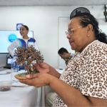 Voluntaria sostiene en sus manos el resultado de la primera sesión del taller