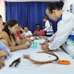 Voluntarios enseñando las manualidades correspondientes para trabajar el árbol de Bonsai
