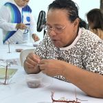 Participante concentrada en manualidades de pedrería