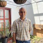 Beneficiario posa con una sonrisa en la huerta casera en el Punto de información