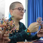 Estudiante trabaja en los acabados de un Árbol artesanal