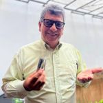Estudiante sostiene semillas con alegría para sembrarlas