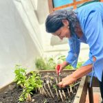 Una mujer transplanta plántulas a la huerta con un rostro lleno de expectativa y alegría